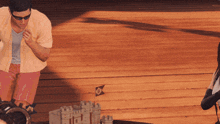 a man standing next to a small model castle with a flag that says ' pirate ' on it