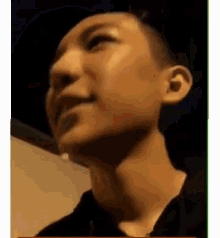 a man with a shaved head is smiling and looking up at the camera .