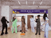 a group of women are dancing in front of a sign that says ' jee '