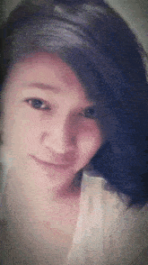 a close up of a woman 's face with a white shirt on