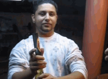 a man in a white shirt is holding a knife in his right hand