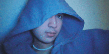 a man wearing a blue hoodie with a hood on his head