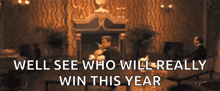 a man sitting in front of a fireplace with the words well see who will really win this year above him