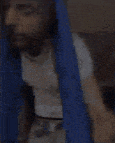 a man is standing in front of a blue curtain and looking through it .