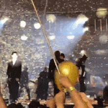 a group of people holding balloons in front of a crowd