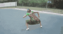 a woman in a green dress is walking down the street