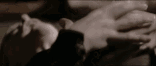 a close up of a person 's hands holding each other in a dark room .