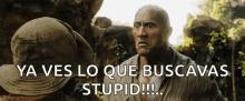 a man in a hat is standing next to another man in a cave and says ya ves lo que buscavas stupid .