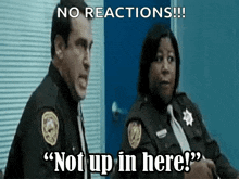 a man and a woman in police uniforms are standing next to each other and the woman is saying " not up in here " .