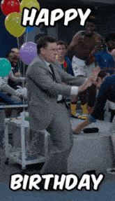 a man in a suit and tie is dancing in front of balloons with the words happy birthday below him