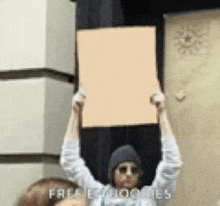 a man is holding a sign over his head that says free ly booties