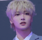 a young man is making a heart with his hands .