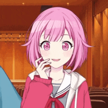 a girl with pink hair and blue eyes is smiling in an auditorium