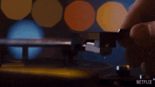 a person is playing a record on a turntable with netflix written on the bottom