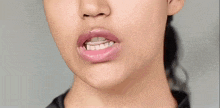 a close up of a woman 's mouth with pink lipstick on
