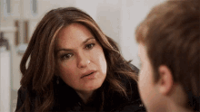 a woman is talking to a young boy who is looking at her