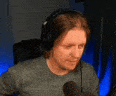 a man is wearing headphones and talking into a microphone .