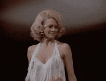 a woman in a white dress with fringe on the sleeves