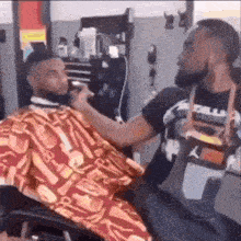 a man is getting a haircut at a barber shop .