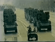 a group of military vehicles are driving down a street