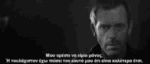a black and white photo of a man with greek writing on the bottom
