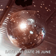a disco ball is hanging from the ceiling with the words save the date 28 june below it