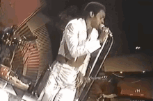 a man singing into a microphone with the letter h on the bottom