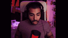 a man wearing headphones is sitting in front of a microphone and making a funny face