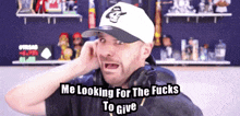 a man wearing headphones and a white hat says me looking for the fucks to give