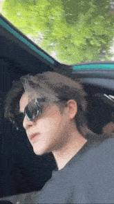 a man wearing sunglasses is sitting in a car .
