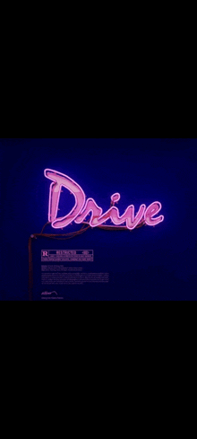 a neon sign that says `` drive '' is lit up in a dark room .