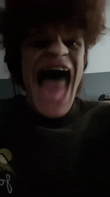 a close up of a person making a funny face with their tongue out .