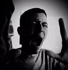 a black and white photo of a man with his mouth wide open