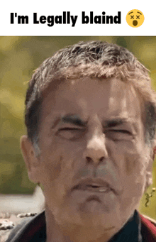 a man is making a funny face with his eyes closed and the words i 'm legally blaind above him