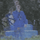 a blurry picture of a man in a blue sweater holding a remote control