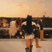 a woman wearing cowboy boots and shorts is standing next to another woman