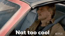a man is sitting in a car with the words " nat too cool " written on the screen