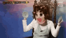 a woman in a mask is sitting in a chair holding a donut