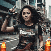 a woman wearing a rockabella t-shirt holds a guitar