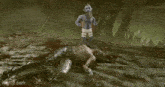 a man is laying on the ground in a video game while two aliens are standing around him .