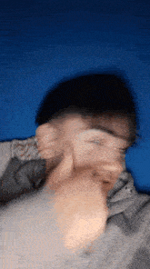 a blurry picture of a person laying on a bed with a blue background