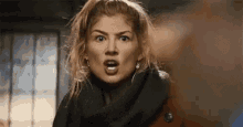 a close up of a woman making a surprised face .