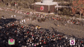 a crowd of people are gathered in front of a building with the number 5
