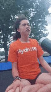 a girl wearing an orange shirt that says hydrate
