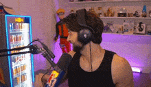 a man is wearing headphones and talking into a microphone .