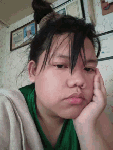a young girl laying on a bed with her hand on her chin