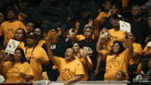 a group of people wearing yellow shirts that say warriors