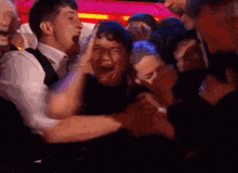 a group of people are laughing and hugging each other