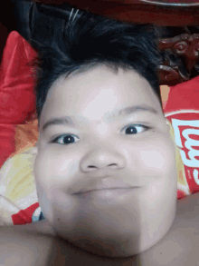 a young boy laying on a bed with a bag of lays chips in the background