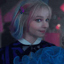 a woman with blue and pink hair is wearing a striped shirt and bow tie